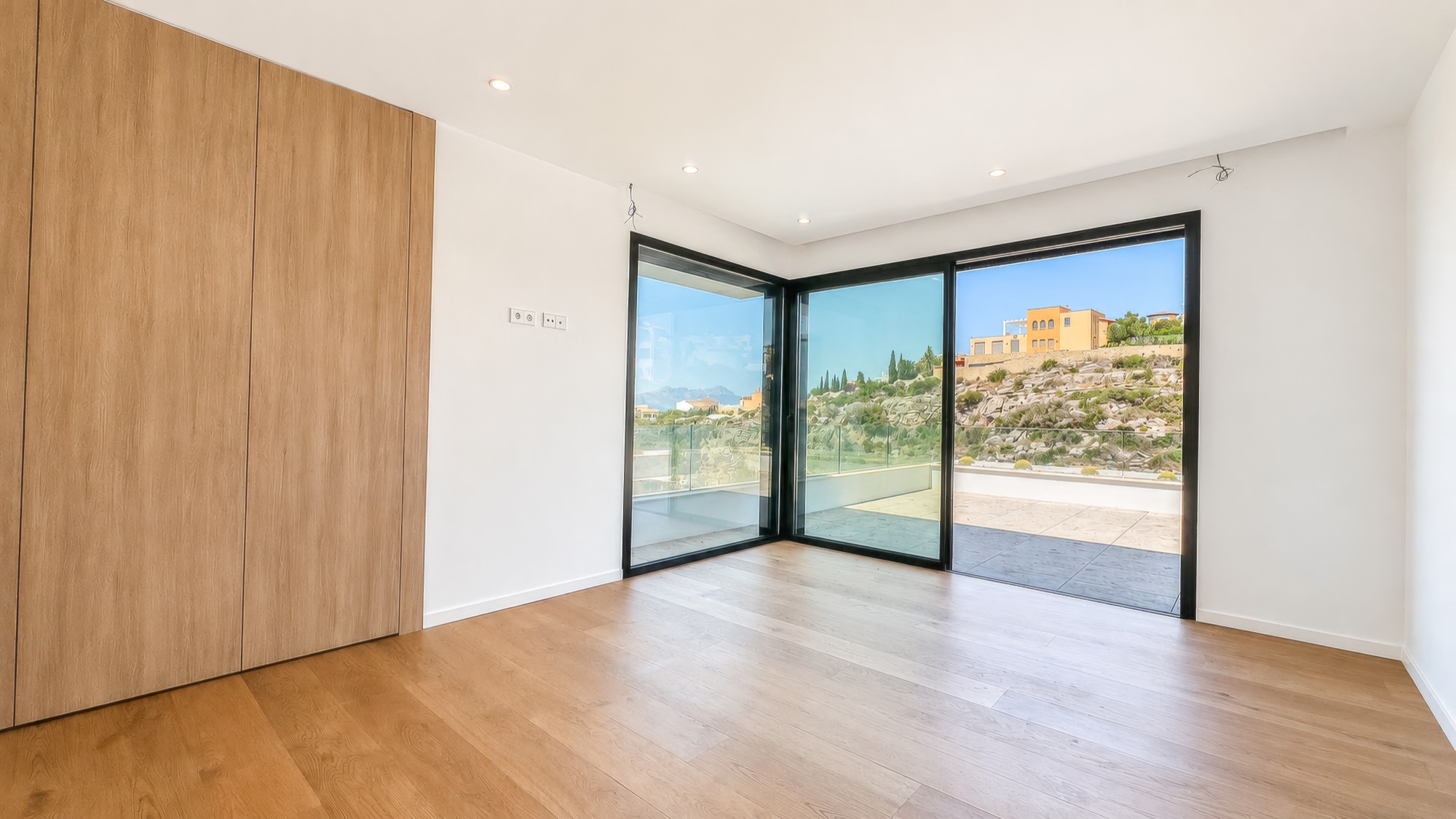 Suite with fitted oak wardrobes and sliding glass door to a terrace