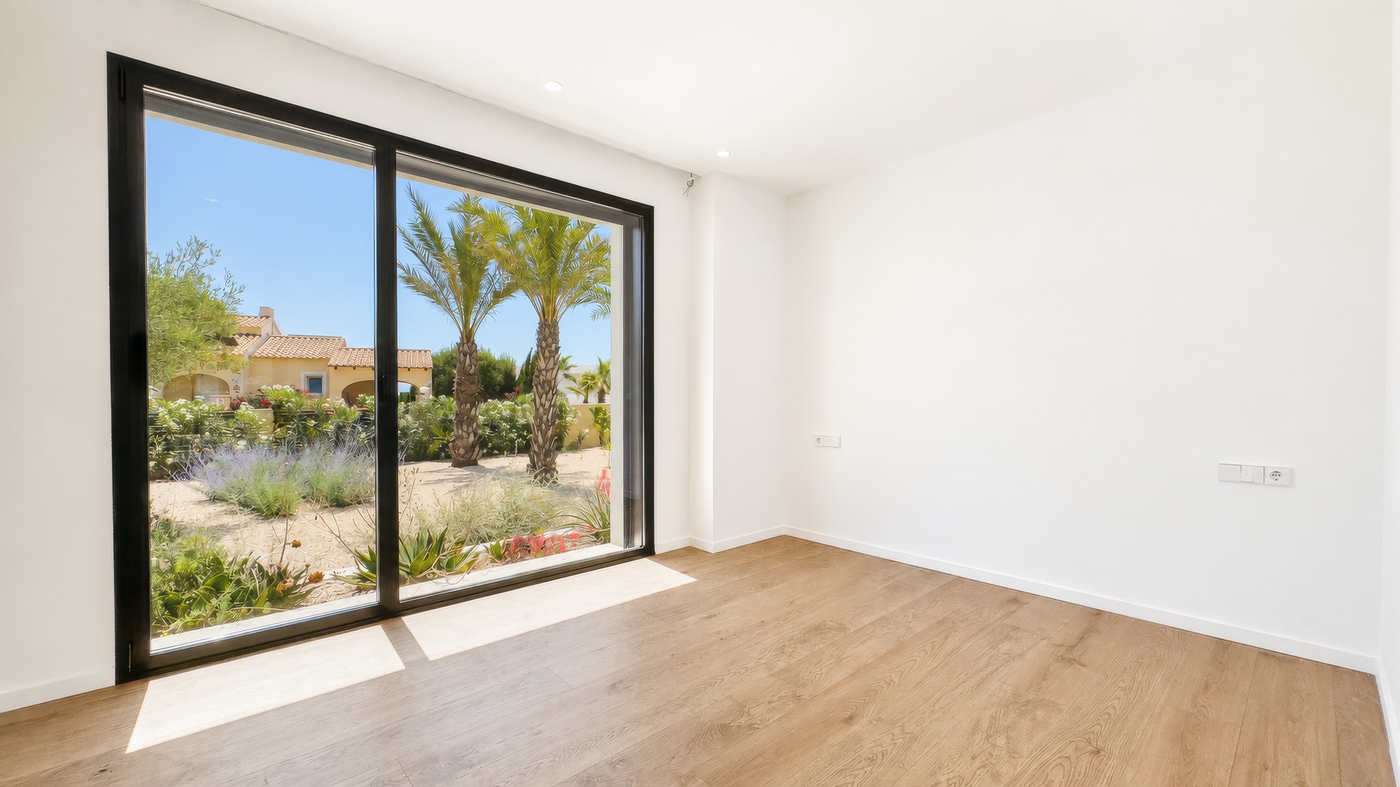 Bright suite with a wide window to the palms and oak parquet