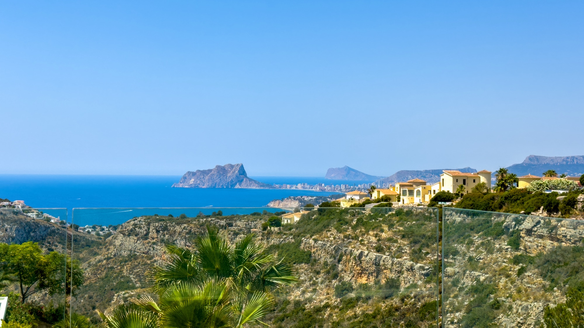 View from the upper terrace over green ridge towards Moraira bay and the sea